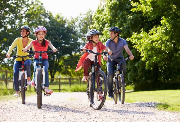 una famiglia che va in bicicletta in un parco