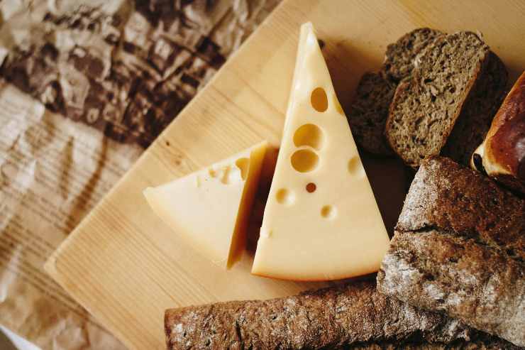 Pezzo di formaggio e pane su un tagliere