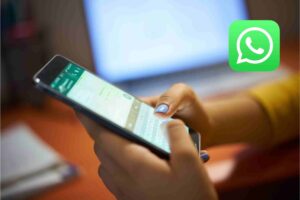 una persona che chatta e il logo di whatsapp
