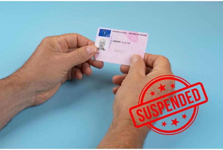 una patente di guida e la scritta sospensione