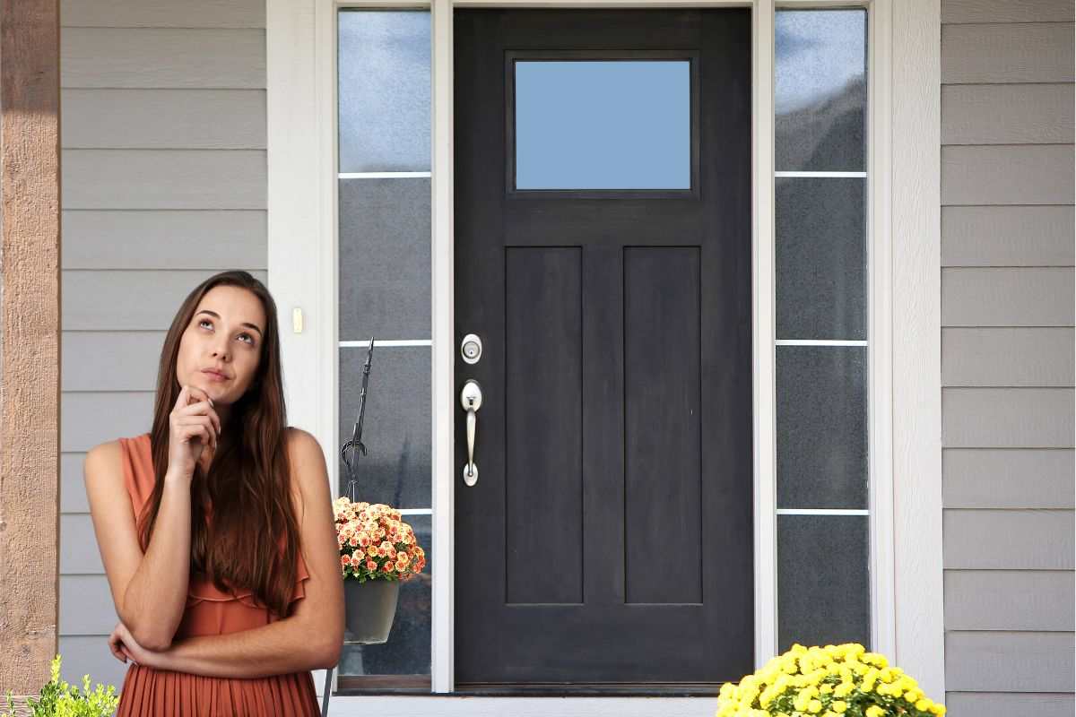una porta di casa e una ragazza dubbiosa