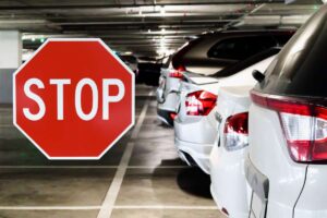 automibili in un parcheggio e segnale di stop
