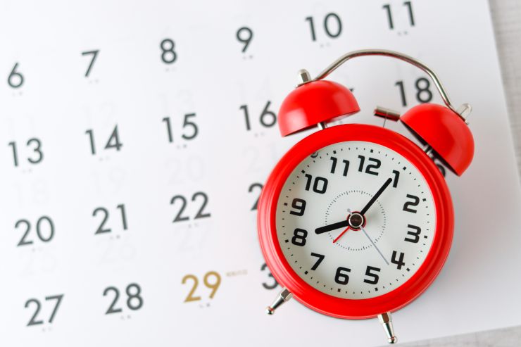 Un calendario sullo sfondo e con sopra un orologio