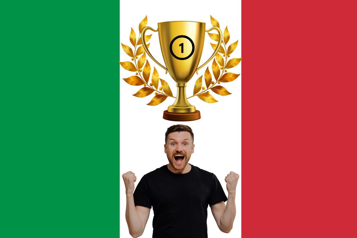 Una bandiera italiana come sfondo ed in primo piano un uomo che esulta ed una coppa del primo posto sopra