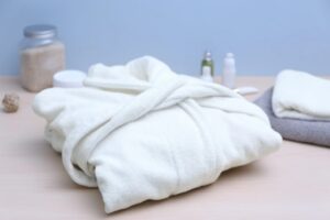 accappatoio piegato e accanto dei sali da bagno