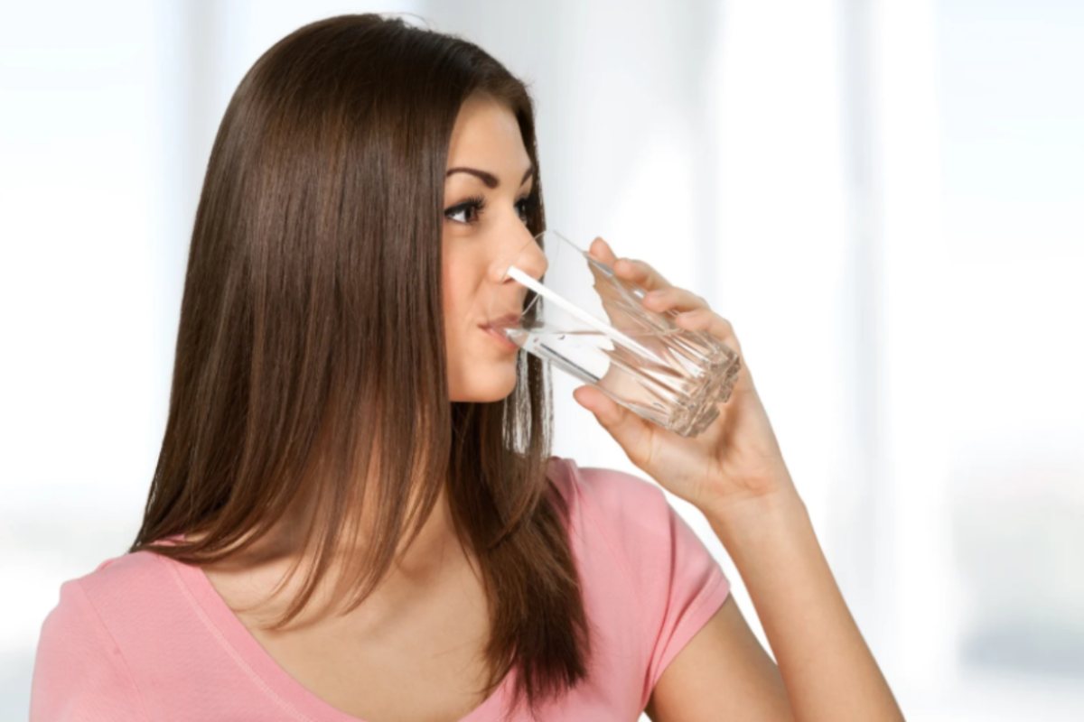donna che beve un bicchiere di acqua