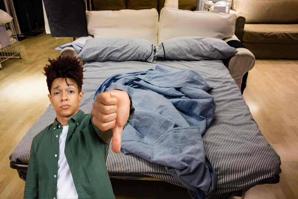 divano letto ed un ragazzo che fa il pollice in giù