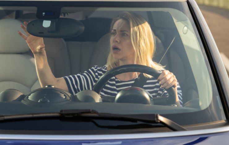donna alla guida preoccupata che guarda nello specchietto