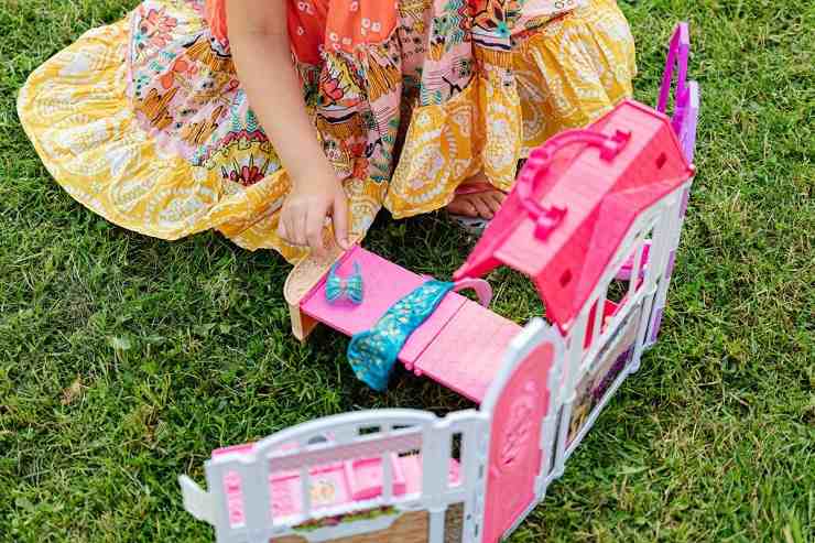 una bambina che gioca con la casa di barbie
