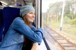 donna che viaggia in treno e guarda fuori dal finestrino
