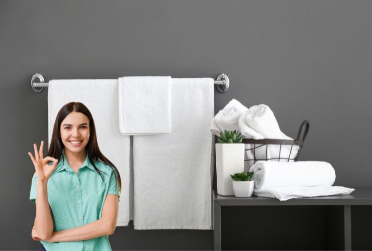 asciugamani bianchi in bagno e una ragazza che fa ok