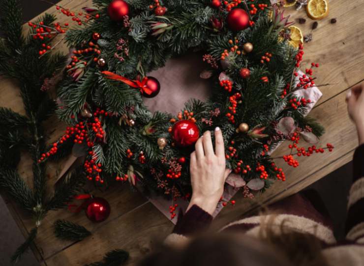donna che realizza una ghirlanda natalizia