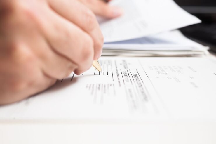 Mano che compila form con penna