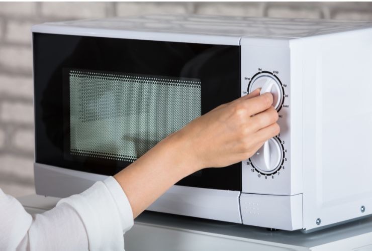 una persona che usa forno a microonde