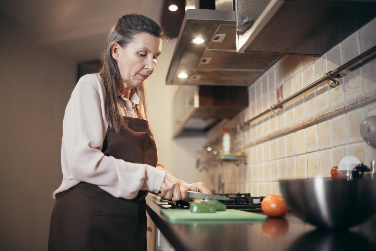 donna in cucina che taglia delle verdure