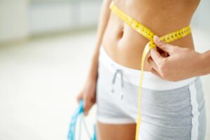 donna che si misura il girovita con un metro da sarta