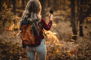 Ragazza in un bosco con macchina fotografica