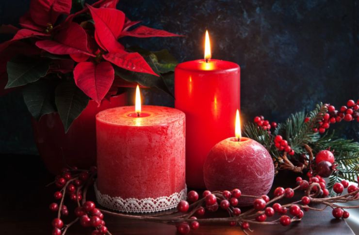 candele rosse natalizie con intorno del vischio e una stella di natale
