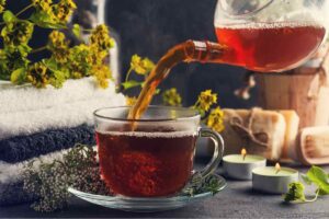 una persona che versa la tisana in un bicchiere