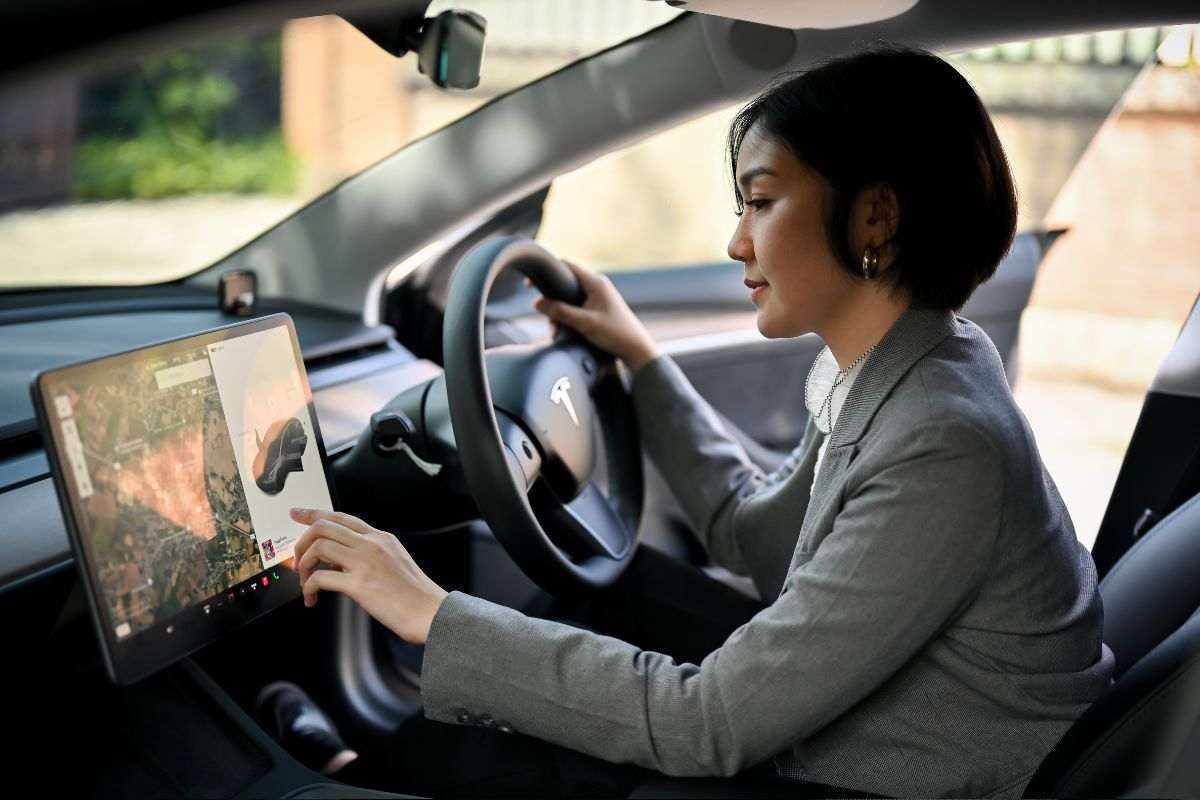 una persona in macchina che tocca il display