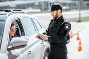 donna in auto e poliziotto al posto di blocco