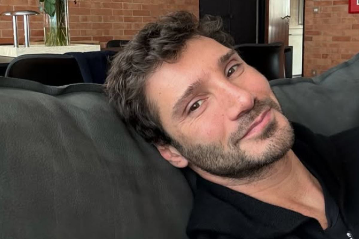 stefano de martino con la testa appoggiata al divano che sorride