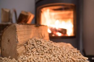 Una stufa a pellet in funzione con in primo piano il pellet