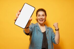 donna che esulta di gioia con in mano il cellulare