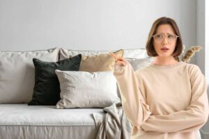 Donna dito alzato indica, cuscini sul divano