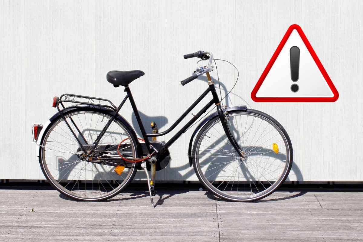 una bici parcheggiata e un segnale di attenzione
